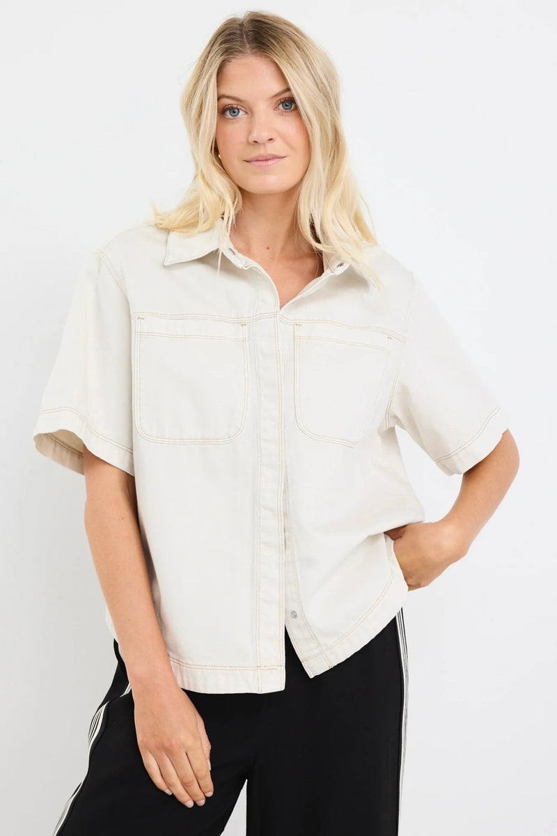 Model wearing ecru short sleeve denim shacket with chest pockets
