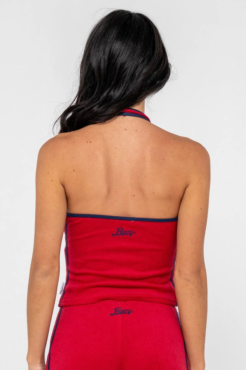 Model wearing red towelling halter neck top with contrast trim