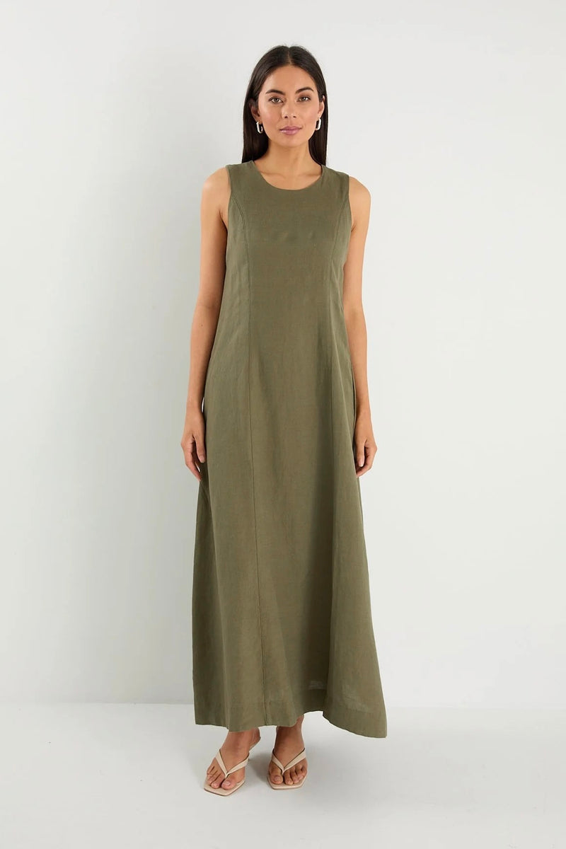 Model wearing Re:Union The Label Easygoing Khaki Linen Blend Sleeveless Crew Neck Midi Dress with relaxed fit, midi length, and side pockets, styled with sandals by the ocean