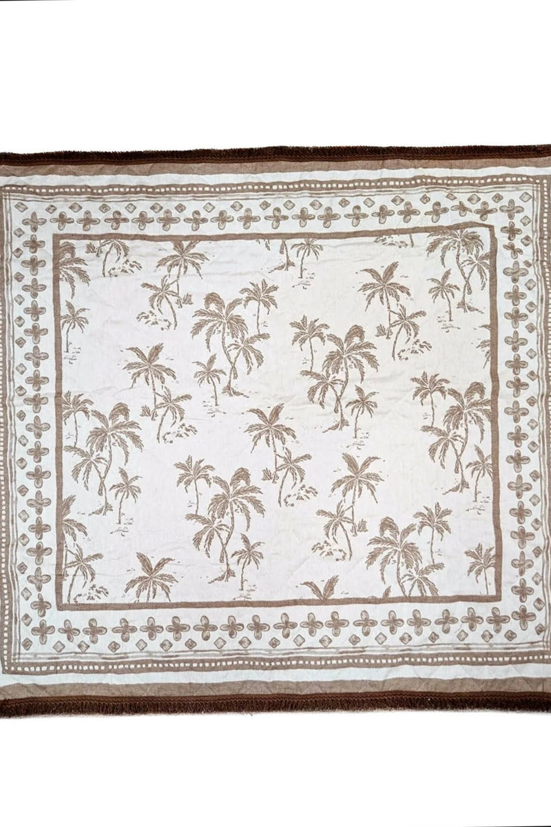 Rolled neutral palm print blanket with brown carry straps