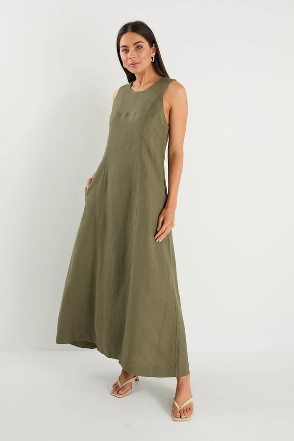 Model wearing Re:Union The Label Easygoing Khaki Linen Blend Sleeveless Crew Neck Midi Dress with relaxed fit, midi length, and side pockets, styled with sandals by the ocean