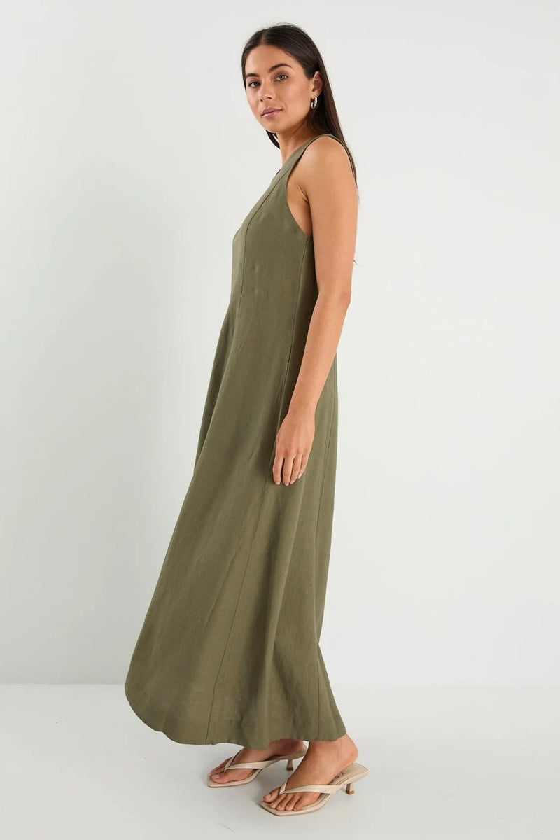 Model wearing Re:Union The Label Easygoing Khaki Linen Blend Sleeveless Crew Neck Midi Dress with relaxed fit, midi length, and side pockets, styled with sandals by the ocean