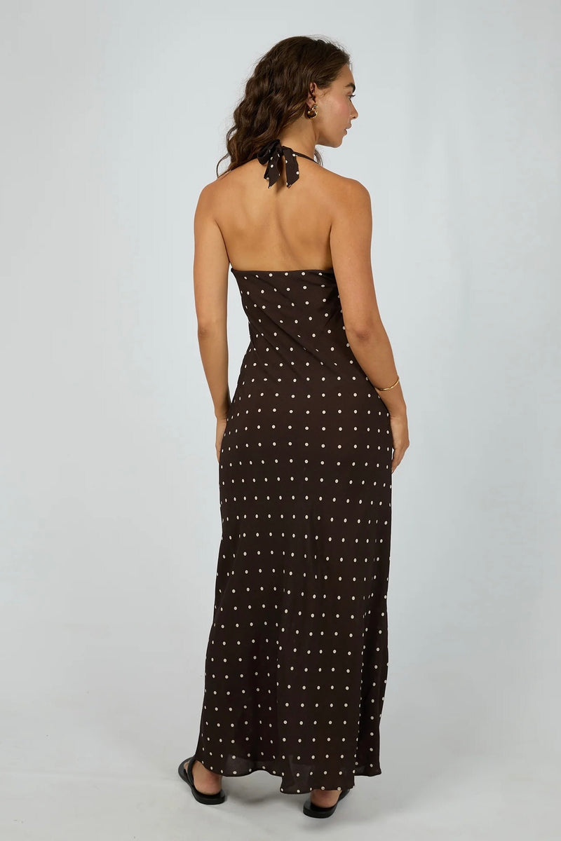 Model wearing All About Eve Emelia Maxi Dress in brown with ivory polka dots, halter neckline, sleeveless design, and flowy maxi length.