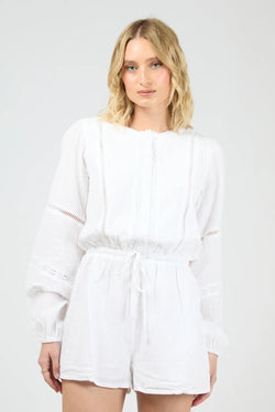 Model wearing the All About Eve Dusty Playsuit in white, featuring long sleeves, lace detailing, and a drawstring waist.
